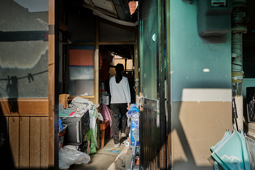 집 밖, 좁고 캄캄한 골목 끝에 있는 화장실로 가는 지우의 뒷모습 사진